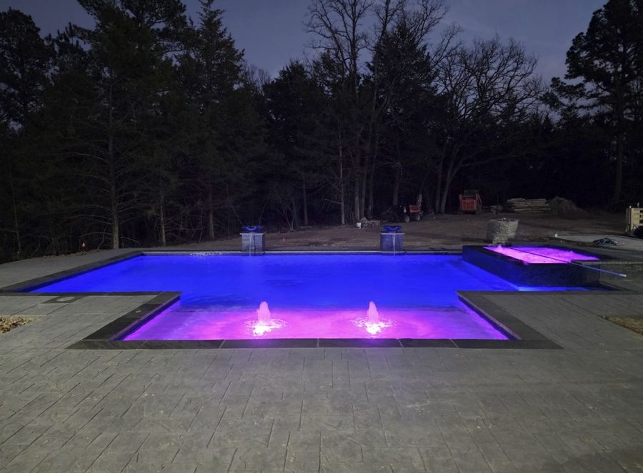Rectangular pool with vibrant blue and purple LED night lighting, Tyler TX