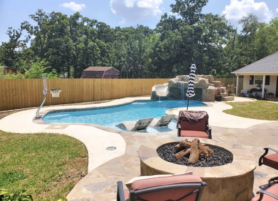 Custom rock waterfall and slide feature built by a Tyler, TX pool builder