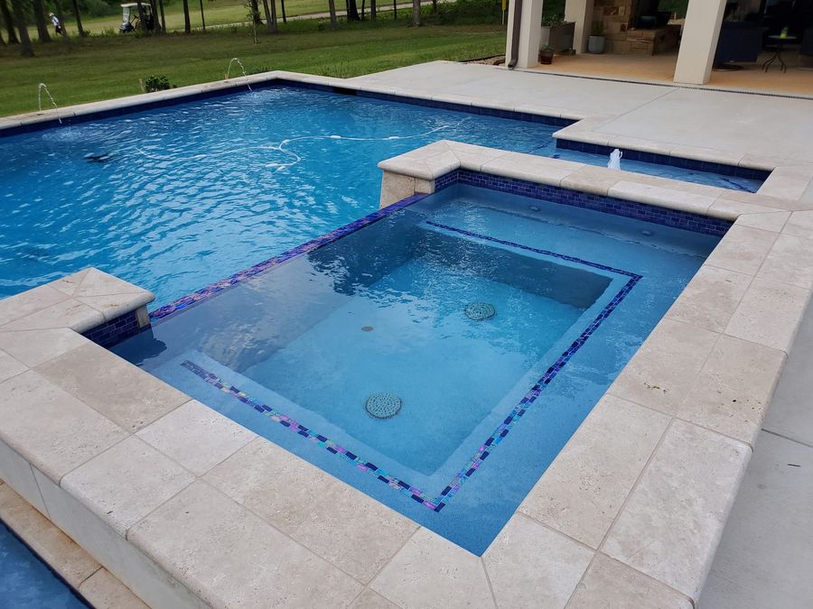 Close-up of iridescent glass tile detailing on a spa, pool renovation detail